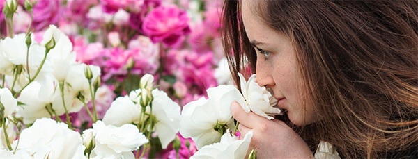 A young woman smelling flowers and wearing designer fine jewelry