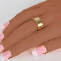 the joyful bar ring worn on the finger of a woman’s hand. This 18K yellow gold designer jewelry collection is available for sale on Ezzykaia.com