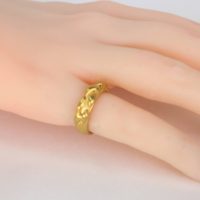 an 18K gold pinky ring worn on the finger of model with fair complexion. This comfortable solid yellow gold band is shown with an 18k cascading gold detail located on the top half of the ring band. The new ezzykaia fine jewelry collection is available for sale on the online fine jewelry store.