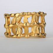 a gold statement ring with 14k gold details interwoven in between each metal squares. The surface of this fine jewelry is also textured and offers an elegant designer ring.