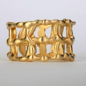 a gold statement ring with 14k gold details interwoven in between each metal squares. The surface of this fine jewelry is also textured and offers an elegant designer ring.