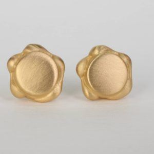 A pair of 18K yellow gold minimaliststud earrings. Theseversatile earrings are designed with a gold detail around the outer edge of the studs. This fine jewelry collection is designed and handcrafted locally in NYC